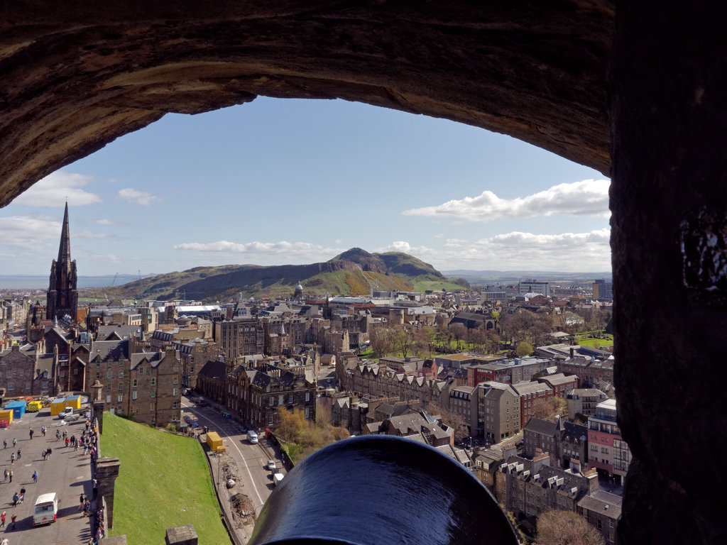 Castle_0034_DxO.jpg - Looking out a cannon port from Edinburgh Castle. You can really see why they put a castle here! Our guest house is at the base of Arthur's Seat and to the right of it. These are all ancient volcanos.