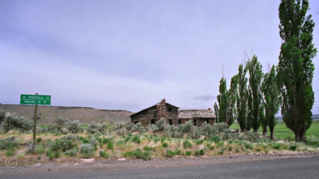 D-007.jpg - Homestead along the Paulina Road at Camp Creek. Wheel ruts of the 1845 Meek wagon train are still visible nearby where they descended the bluff to the river. Mark Carson moved his family here in 1884. It served as a post office and stage stop on the Burns road. In 1889 the Glenns bought the property and operated the ranch for many years.